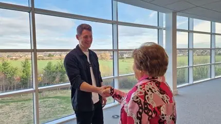 Anna shaking hands with a ARC monitor