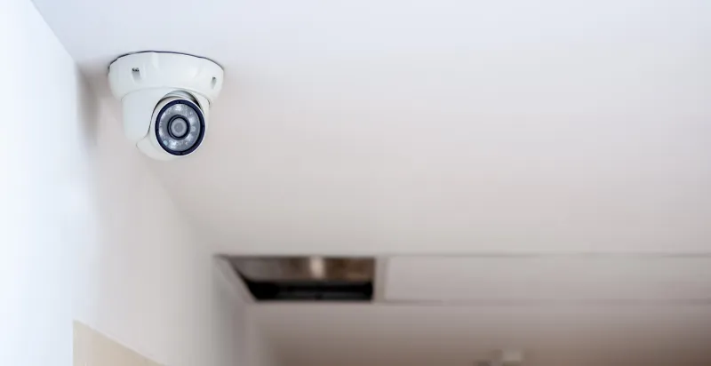 CCTV camera mounted on a white office ceiling